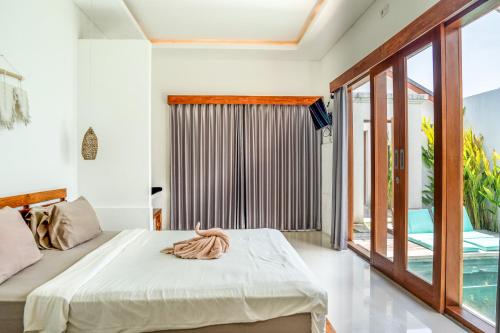 um quarto com uma cama e uma varanda em KIKI VILLAGE PADDY FIELD em Canggu
