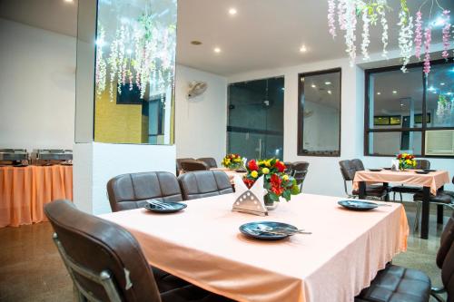 a dining room with a table and chairs and windows at Nikko Blue - Boutique Hotel in Gurgaon