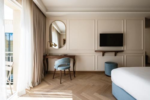 Schlafzimmer mit einem Bett, einem Schreibtisch und einem TV in der Unterkunft Palazzo Castagna Boutique Hotel in Hal Ghaxiak