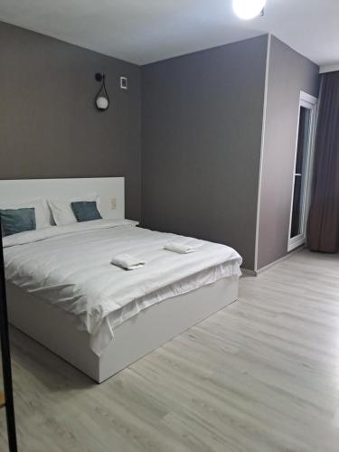 Ira & Vaso's guest house Borjomipark في بورجومي: غرفة نوم مع سرير أبيض كبير في غرفة