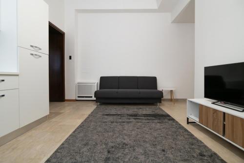 a living room with a black couch and a television at Residenza Corso Palladio 159 in Vicenza