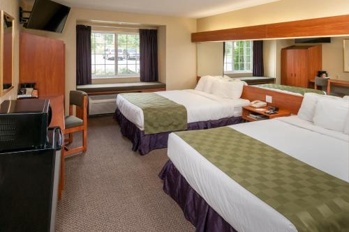 a hotel room with two beds and a television at Microtel Inn & Suites Beckley East in Beckley