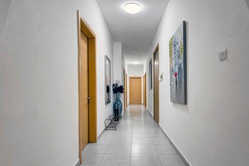 a hallway with white walls and a tile floor at St Julians apartment 1 in St Julian's