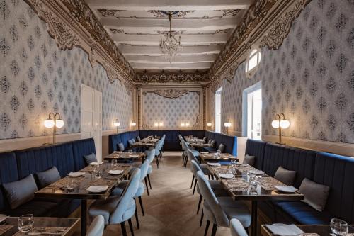 una fila de mesas en una habitación con papel pintado en Palazzo Castagna Boutique Hotel, en Hal Ghaxiak