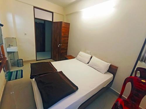 a small bedroom with a bed and a chair at Jayalaxmi Comforts in Hubli