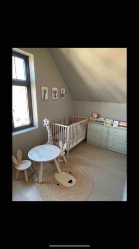 a baby room with a crib and a table and chair at Sentralt hus in Egersund