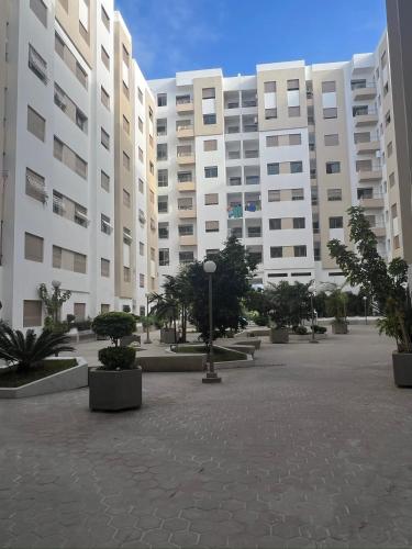 a large building with a courtyard in front of it at Appartement Jardins de Tanger , 2 chambres in Tangier