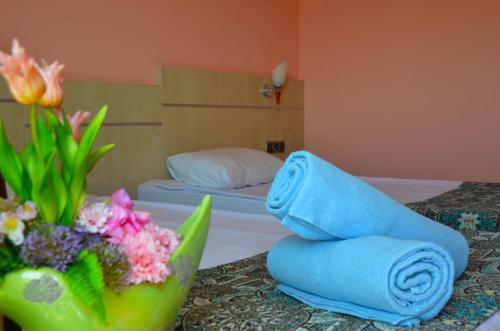 a bedroom with two beds and a vase of flowers on a table at Sun Beach Hill Hotel - All Inclusive in Side
