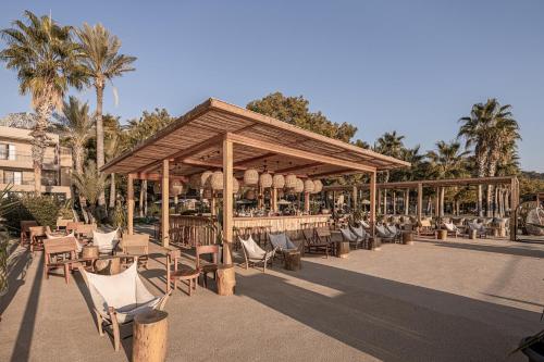 a pavilion with chairs and tables and palm trees at Balmy Beach Resort Kemer in Kemer