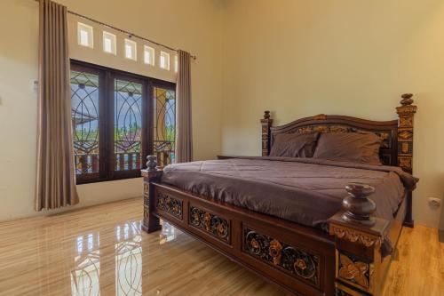 ein Schlafzimmer mit einem Bett und einem großen Fenster in der Unterkunft Bait Nahwa in Mataram