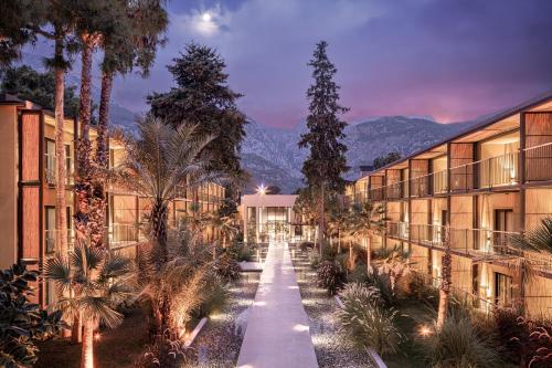 a long walkway between two buildings with palm trees at Balmy Beach Resort Kemer in Kemer