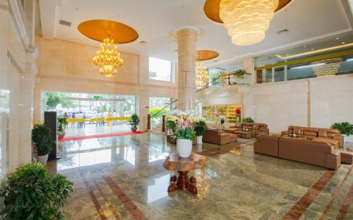 a lobby with couches and flowers in a building at Van Phat Riverside Hotel in Can Tho