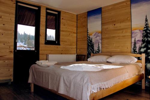 a bedroom with a bed in a room with windows at ЛемГора in Vorokhta