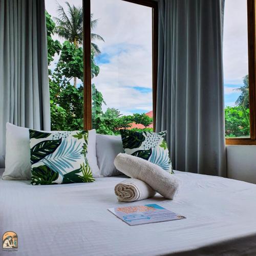 a bedroom with a bed with a large window at Luna Tres Homestay Siargao in General Luna
