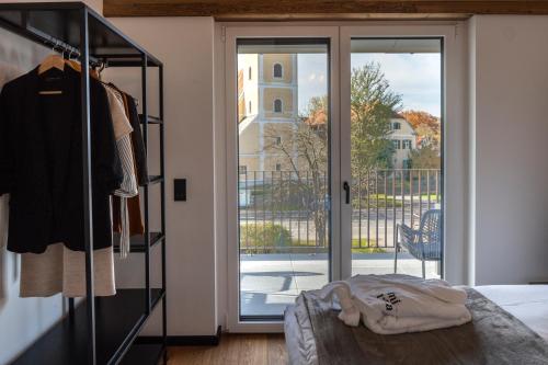 a bedroom with a sliding glass door with a balcony at RiverVista Apartments by mi_vida in Bad Waltersdorf