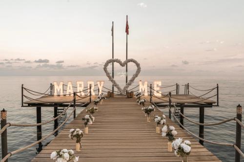 a wooden pier with a heart altar on the water at Balmy Beach Resort Kemer in Kemer