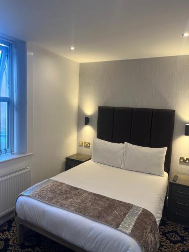 a bedroom with a large bed with a black headboard at Shores Holiday Apartments in Blackpool