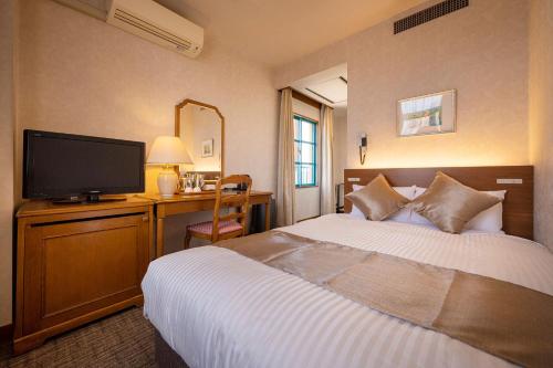 a hotel room with a bed and a flat screen tv at TAOYA Saikaibashi in Sasebo