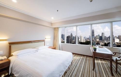 Habitación de hotel con cama y ventana grande en Jin Jiang Tower en Shanghái