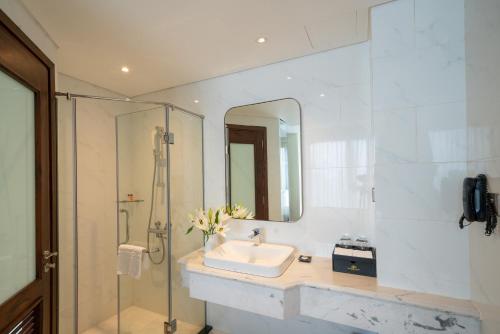 a bathroom with a sink and a shower with a mirror at Northern Charm Hotel in Ho Chi Minh City