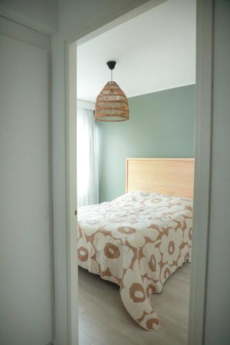 a bedroom with a bed and a pendant light at Condo Portsa - Viihtyisä asunto keskustassa in Turku