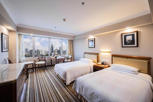 pokój hotelowy z 2 łóżkami i oknem w obiekcie Jin Jiang Tower w Szanghaju