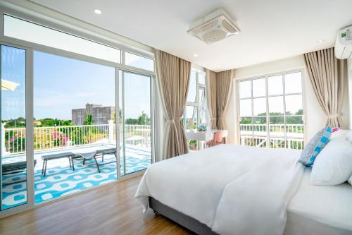 a bedroom with a large bed and a balcony at Mia Luxury Villa Bình Châu in Xuyên Mộc
