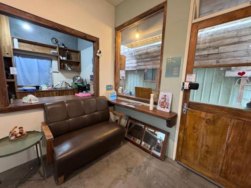 a living room with a leather chair and a table at MatchBox Hostel in Longjing