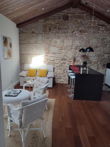 a living room with a couch and a stone wall at O Iniño casita rural costera in O Grove