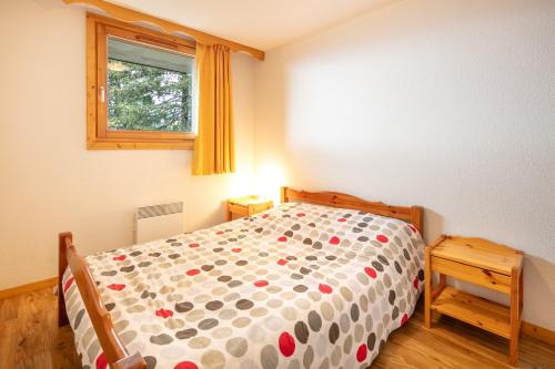 a small bedroom with a bed and a window at Le Chartreuse - Apt de charme in Chamrousse