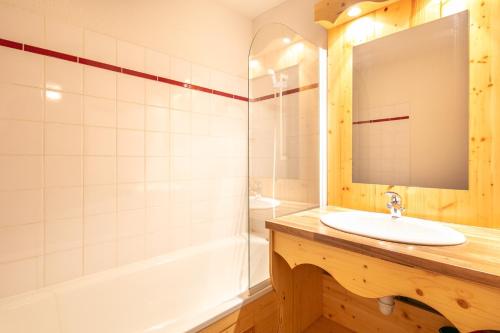 a bathroom with a sink and a shower and a mirror at Le Chartreuse - Apt de charme in Chamrousse