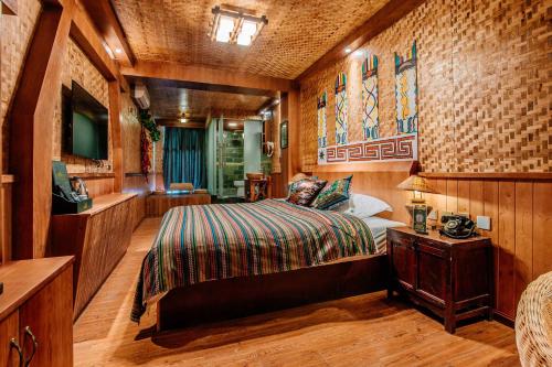 a bedroom with a bed and a television in it at 26Life Yunnan Ethnic Creative Inn in Jinghong