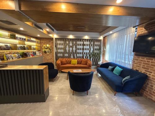 a living room with blue couches and a tv at Basilissis Hotel in Istanbul
