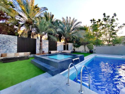 a swimming pool in a backyard with palm trees at Royal private pool, Lux 7-bedroom villa on Marina in Dubai