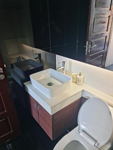 a bathroom with a white sink and a toilet at Art Patong Residence in Patong Beach