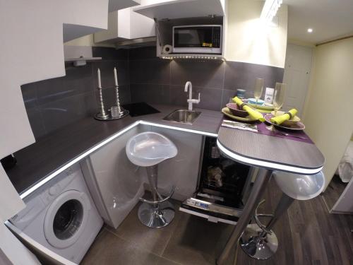 a kitchen with a sink and a washing machine at Black and white in Budapest
