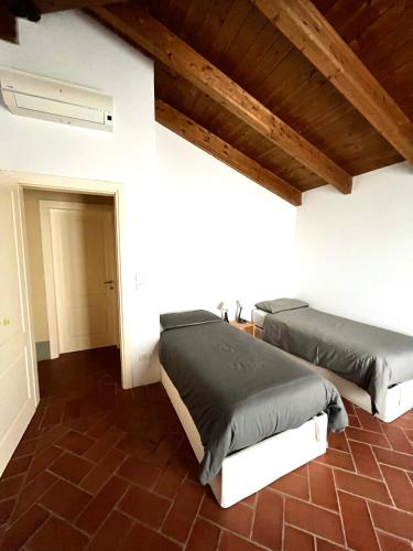 two beds in a room with wooden ceilings at Country house 15km from Bologna in Budrio