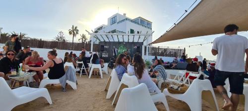 a group of people sitting in chairs on the beach at Sunset Beach 4 Bedroom Villa 200m to Beach+Fast WIFI in Corralejo