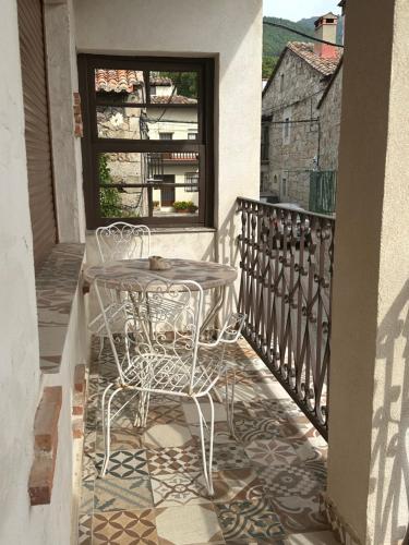 a patio with a table and chairs on a balcony at D' Anta Casa de la Luz in Piedralaves