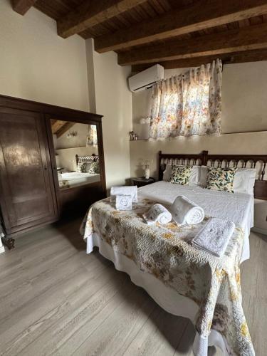 a bedroom with a large bed and a large mirror at D' Anta Casa de la Luz in Piedralaves