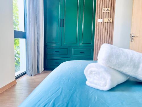 - un lit bleu avec 2 oreillers blancs au-dessus dans l'établissement 3 bedrooms in the Villa - Vinhome Ocean Park, à Gia Lâm Pho