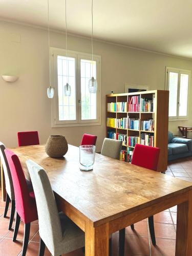 a dining room with a wooden table and red chairs at Country house 15km from Bologna in Budrio