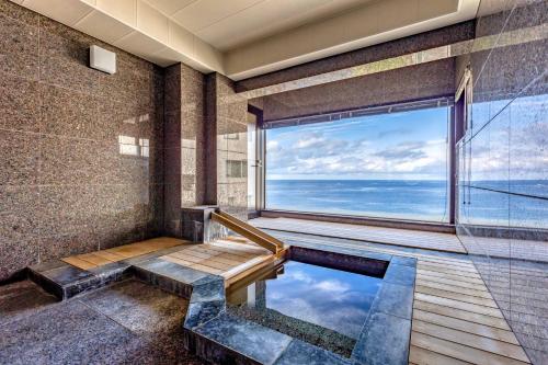 a bathroom with a plunge pool and a large window at SEA 351 in Shirahama