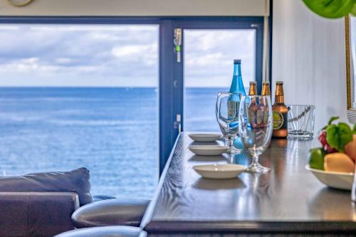 een tafel met wijnglazen en uitzicht op de oceaan bij SEA 351 in Shirahama