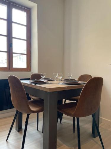 - une table avec des chaises et des verres à vin dans l'établissement Appartement entre la gare St Charles et Vieux port, à Marseille