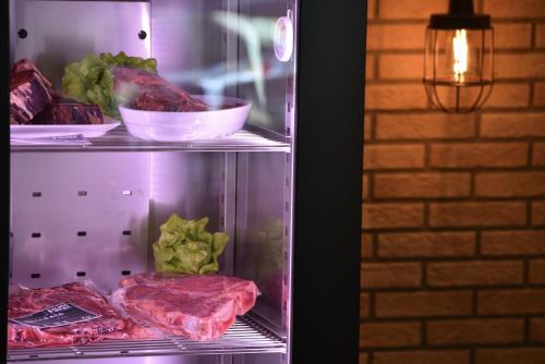an open refrigerator filled with meat and lettuce at Hotel Galli's - Centro in Livigno