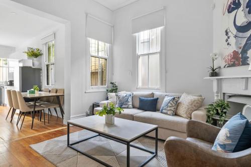 a living room with a couch and a table at Newtown Nest - Chic Terrace Living off King Street in Sydney