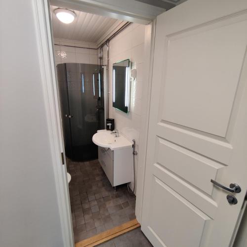 a bathroom with a white door and a sink at SEA - 3 Bedrooms in Kristiinankaupunki