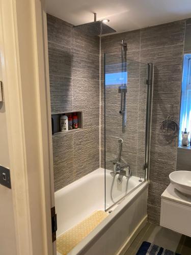 y baño con ducha, bañera y lavamanos. en Ruislip Guest House en Ruislip