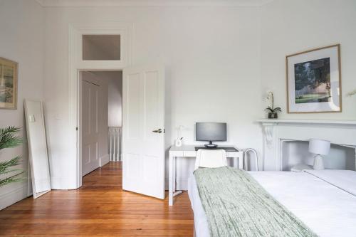 a bedroom with a bed and a desk with a television at Newtown Nest - Chic Terrace Living off King Street in Sydney